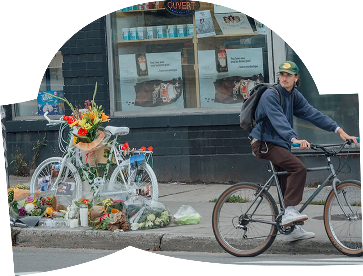 Vélo fantôme fleuri sur l’avenue du Parc, devant lequel passe une personne à vélo.